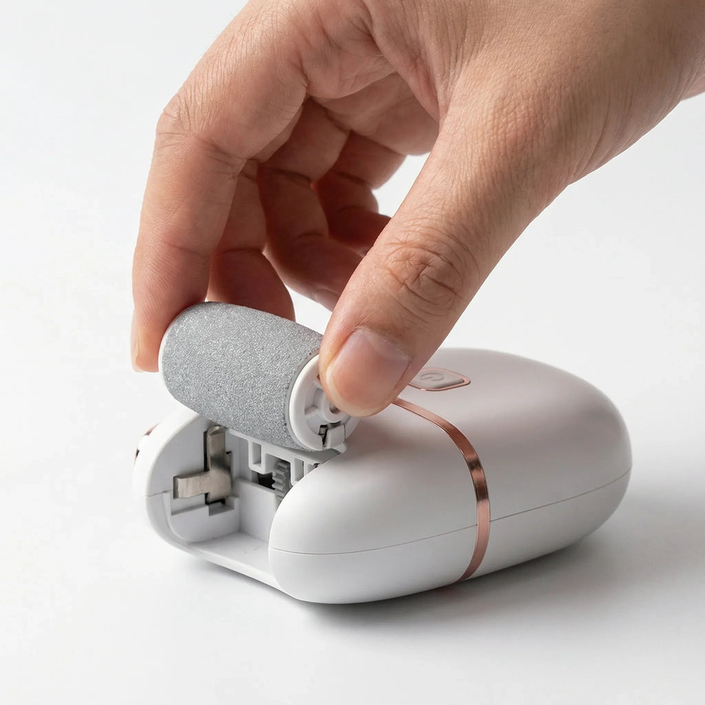 Main remplaçant la tête d’un appareil électrique de soin des pieds blanc et argenté